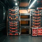 Side van view of the Kia PV5 Cargo Milwaukee Packout Toolbox Compatible Van Racking (Full OS) displayed with Milwaukee toolboxes