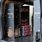 Rear van NS angle view of the Kia PV5 Cargo Milwaukee Packout Trolley Compatible Van Racking (x3 V1) displayed with Milwaukee toolboxes and trolley