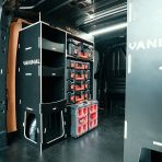 Rear van OS side angle view of the Transit Custom 2023+ LWB Hexaboard Milwaukee PackOut Double Rear Racking - displayed with Milwaukee tools