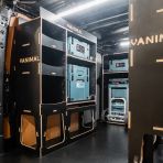 Rear van NS angle view of the Kia PV5 Cargo Makita Makpac Trolley Compatible Van Racking (x3 V1) displayed with Milwaukee toolboxes, trolley and top trays