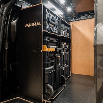 Side van view of the bulkhead section of the Kia PV5 Cargo 2025- DeWalt TSTAK Trolley Compatible Van Racking (x3 V1) displayed with DeWalt TSTAK toolboxes and top trays