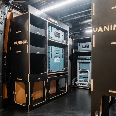 Rear van NS angle view of the Kia PV5 Cargo Makita Makpac Trolley Compatible Van Racking (x3 V1) displayed with Milwaukee toolboxes, trolley and top trays