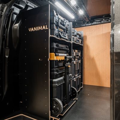 Side van angle view of the Kia PV5 Cargo DeWalt TSTAK Trolley Compatible Van Racking - Bulkhead displayed with DeWalt TSTAK trolley and toolboxes